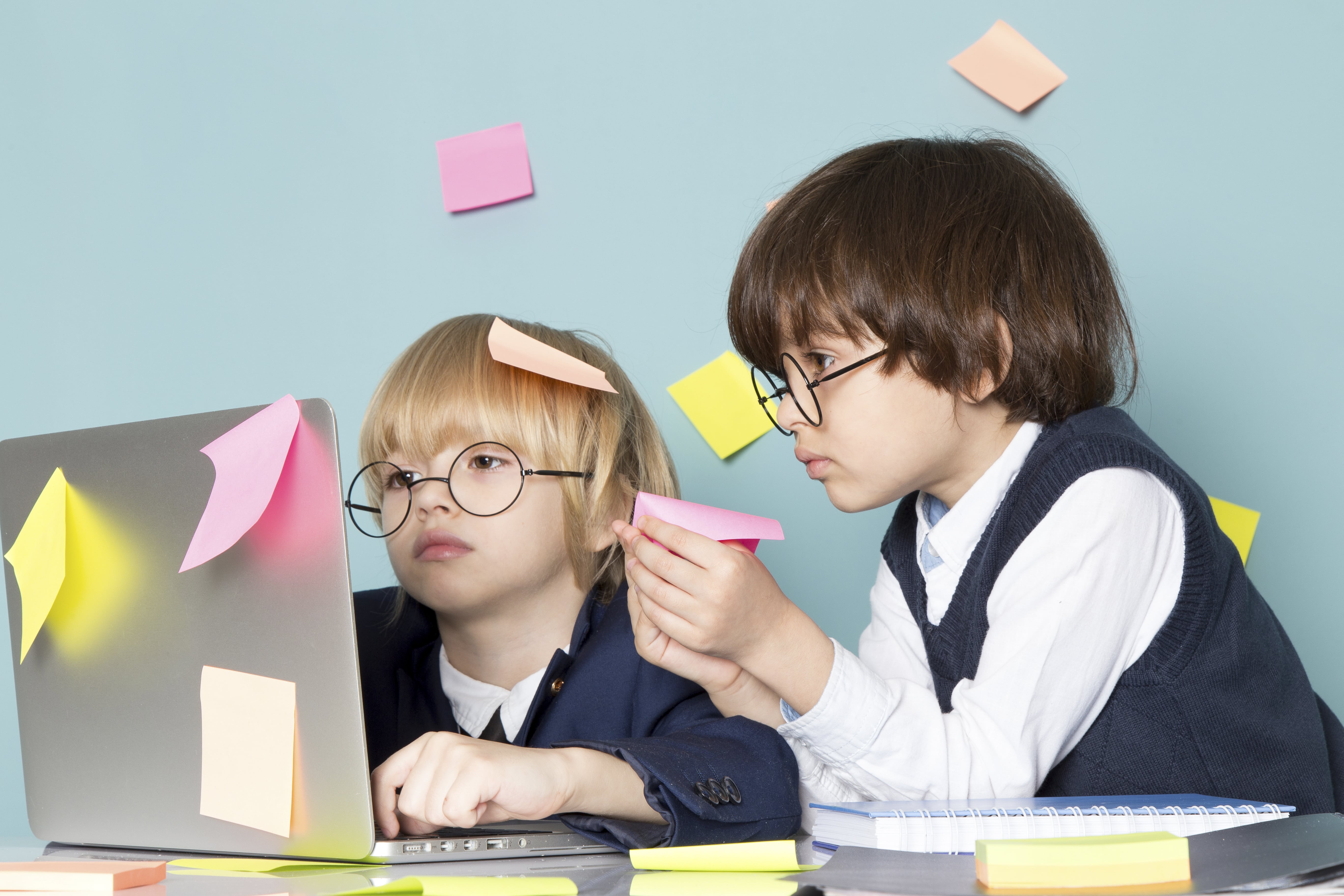front-view-cute-business-boy-blue-classic-suit-posing-front-silver-laptop-along-with-other-boy-discussing-glueing-notes-working-business-work-fashion-min