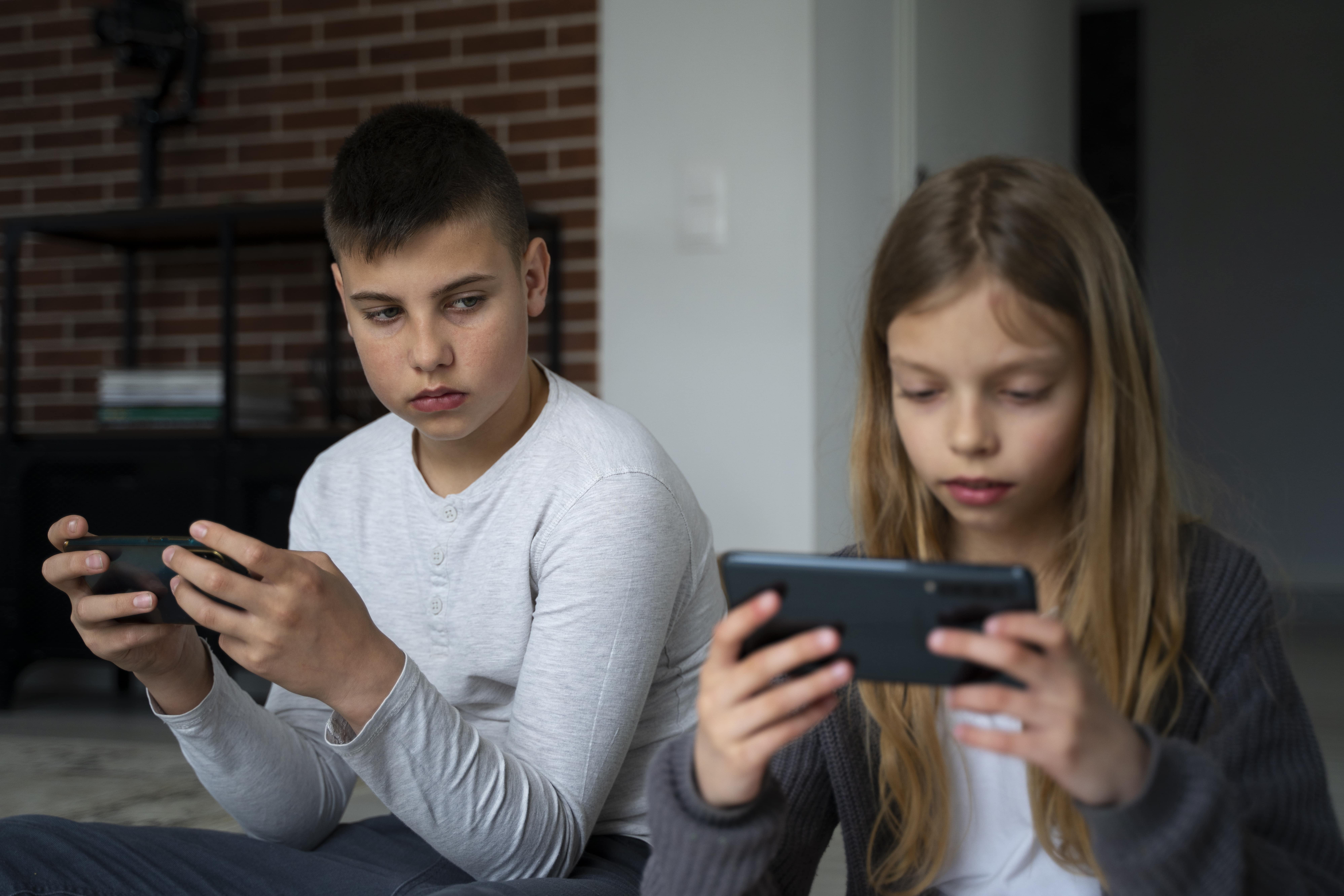 medium-shot-kids-with-smartphones-min